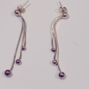 Silver drop style earrings with three chains each with different sized ball